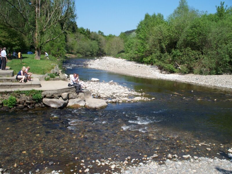 people sitting by the side of the river where the waters of two rivers meet